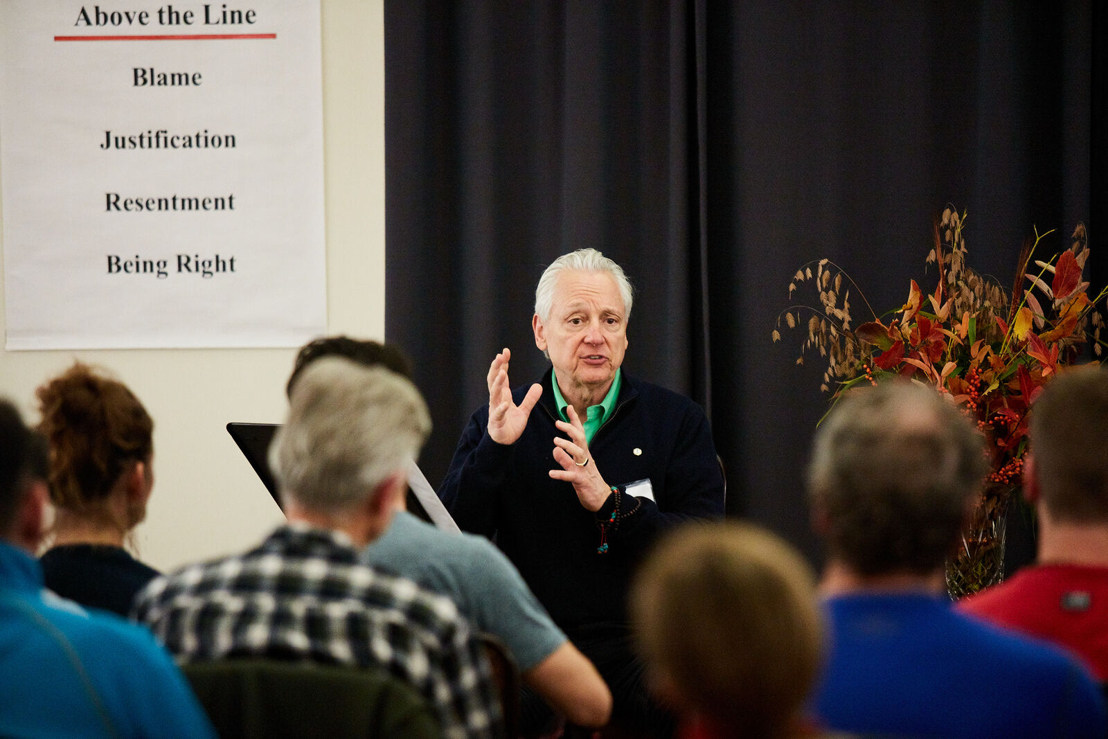 Fleet Maull teaching beside a flip chart reading Above the Line: Blame, Justification, Resentment, Being Right